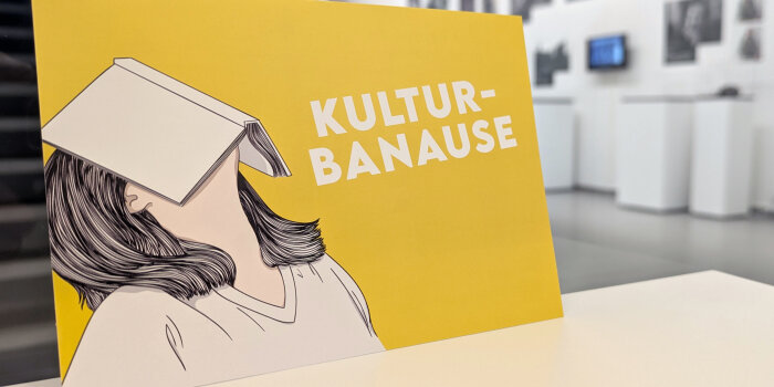 Foto: Postkarte zum Kultursemesterticket © Stadtverwaltung Erfurt gelbe Karte mit Grafik einer Person, die ein aufgeschlagenes Buch auf dem Gesicht hat, und Schriftzug Kulturbanause