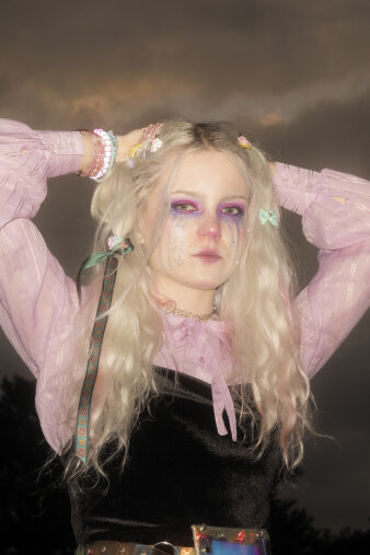 Fotografie einer Frau mit blonden Haaren vor einem dunklen Himmel