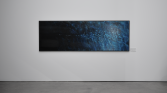 Eine graue Wand mit einem querformatigen Bild in Blautönen