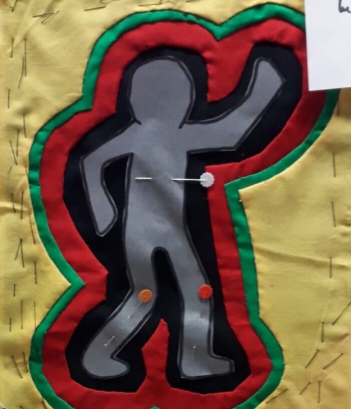Molamuster farbige übereinander gelegte Stoffe mit einer grauen Figur in der Mitte