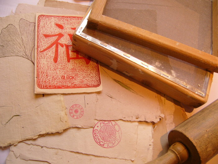 bedruckte Papiere mit zwei Siebdruckrahmen und einer Holzrolle 