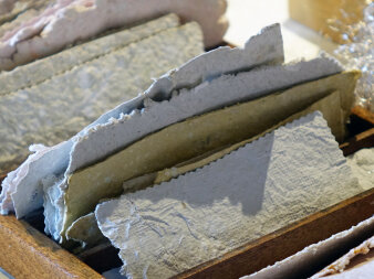 Mehrere Blätter handgeschöpftes Papier in einer Holzbox