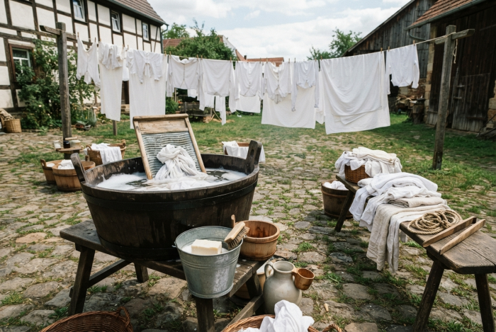 Ein Innenhof in dem Wäsche hängt und im Vordergrund verschiedene Schüüseln mit Wasser stehen