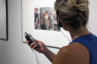 Junge Frau in der Ausstellung mit Audioguide in der Hand