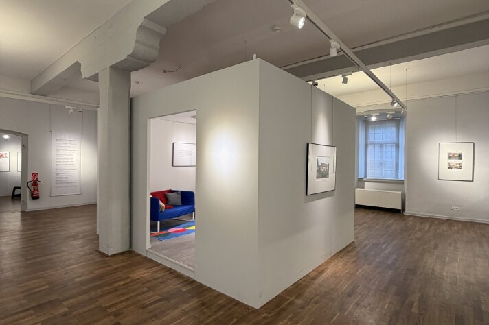 Ausstellungsraum mit Holzboden und weißem Cubus in der Mitte