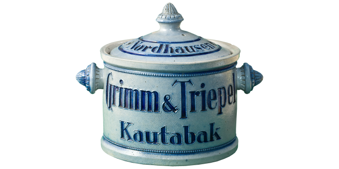 Kleiner blauer Keramiktopf mit Deckel, er trägt die Aufschrift "Grimm und Triepel Kautaback"